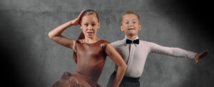 Young boy and girl together in wide dance pose