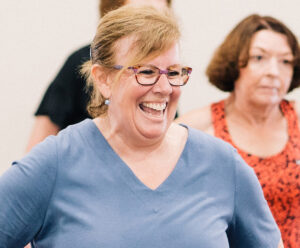 mature woman with large smile during dance class