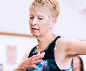 mature woman looks down during dance class