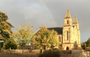 Wdie-shot of Polmont parish church viewed with rainbow in sky