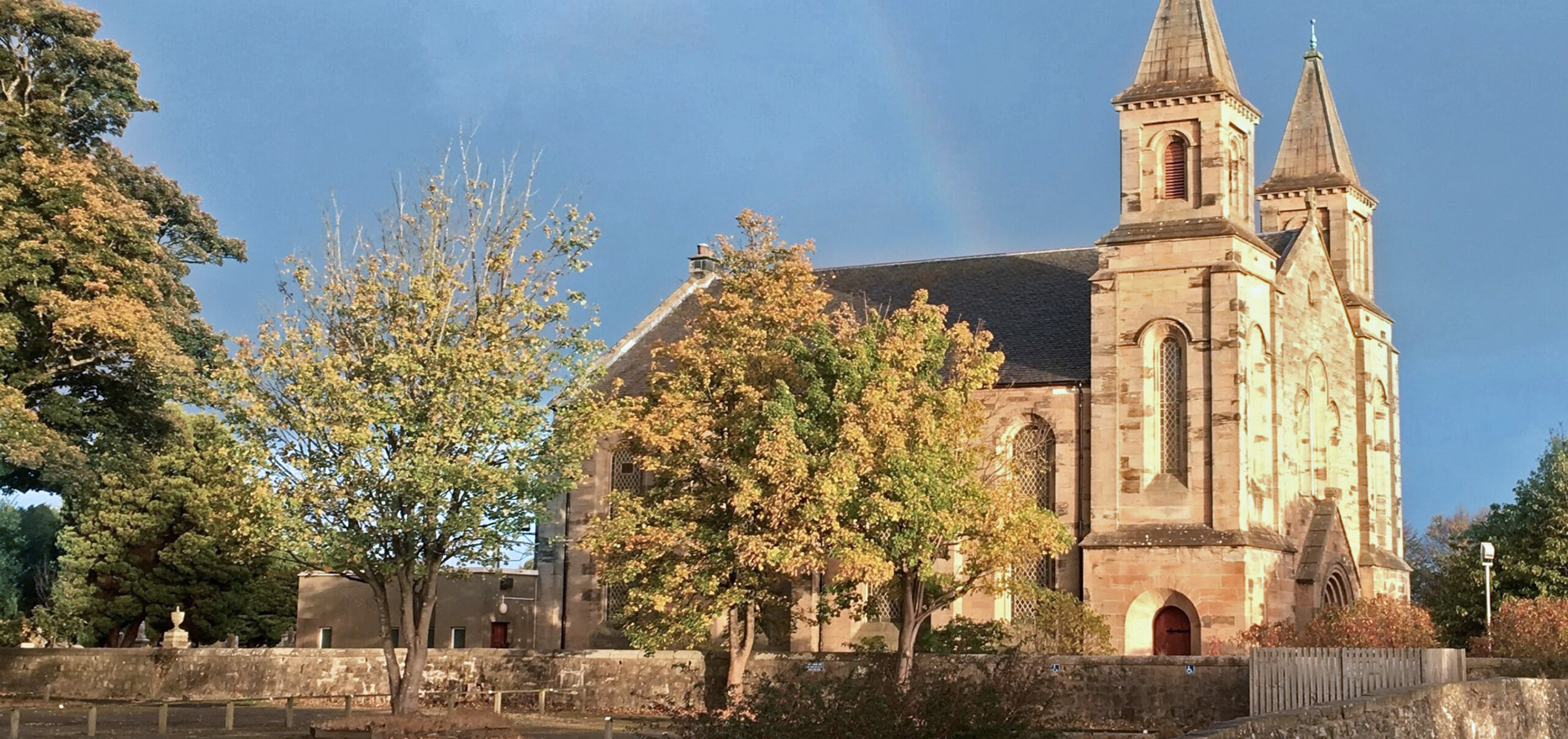 Polmont parish church viewed from road with rainbow in sky